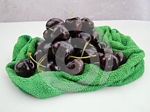 Fresh cherries fruits wrapped in cloth on green background