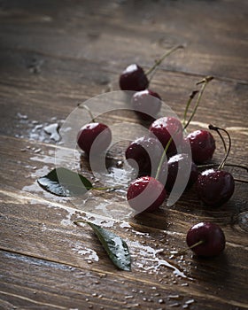 Fresh Cherries with water drops on a wooden table