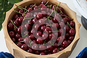 Fresh cherries in wooden bowl on table, close-up. Red cherry berries