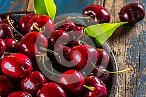 Fresh cherry on black plate, wooden background