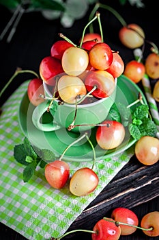 Fresh cherry in a Cup on a dark rustic wooden table. Background with space for copying. Selective focus.