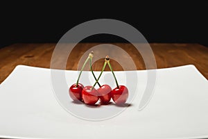 Fresh cherry on plate on wooden blue background. fresh ripe cherries. sweet cherries.