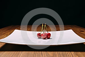 Fresh cherry on plate on wooden blue background. fresh ripe cherries. sweet cherries.