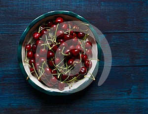 Fresh cherry on plate on wooden blue background. photo