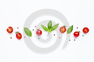 Fresh  cherry tomatoes with basil leaves and different type of peppercorns on white background.