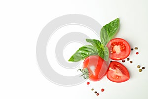 Fresh cherry tomatoes with basil and spices on white background, space for text and top view