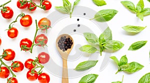 Fresh cherry tomatoes with  black pepper  and  basil leaves on white