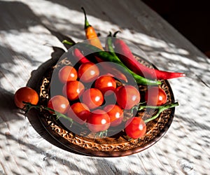 Fresh cherry tomatoes and  chilly pepper in a ceramic plate