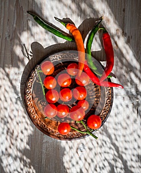 Fresh cherry tomatoes and  chilly pepper in a ceramic plate