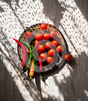 Fresh cherry tomatoes and  chilly pepper in a ceramic plate