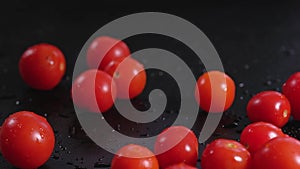 Fresh cherry tomatoes close-up on a black background. Organic products, agriculture