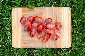 Fresh cherry tomatoes on the old wooden cutting board, closeup food, outdoors shot.