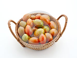 Fresh cherry tomatoes in the rattan basket isolated on white background.