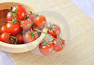 Fresh cherry tomatoes on the vine in a wooden plate