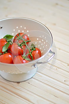 Fresh cherry tomatoes in a vintage colander