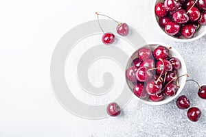 Fresh cherry in white mug on stone table Close-up Water drops Top view Copy space