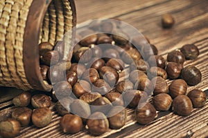 Fresh chestnuts in the basket falling on a brown wooden table