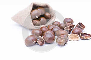 Fresh Chestnuts in yute isolated on white photo