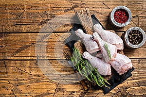 Fresh Chicken drumsticks legs with skin, raw poultry meat. Wooden background. Top view. Copy space