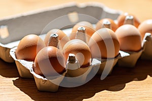 Fresh Natural healthy food and organic farming concept.Chicken eggs in carton box on wooden table.Top view