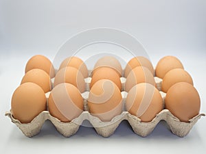 Fresh chicken eggs in a carton box ,cardboard package made of recycled waste paper on white background