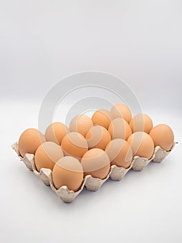 Fresh chicken eggs in a carton box ,cardboard package made of recycled waste paper on white background