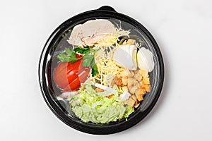 Fresh chicken salad in a plastic package to take away for lunch on white background