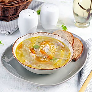 Fresh chicken soup with vegetables and stelline pasta in a bowl