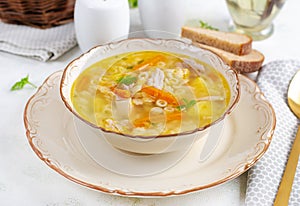 Fresh chicken soup with vegetables and stelline pasta in a bowl