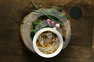 Fresh chicken soup on wooden table.