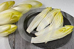 Fresh Chicory Salad leaves placed on a grey stone board