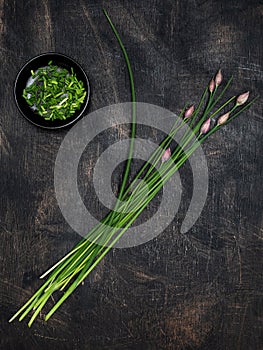 Fresh chives on dark vintage table. Overhead shot with copy space