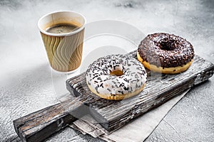 Fresh Chocolate artisan donuts and take away coffee. White background. Top view