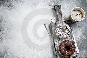 Fresh Chocolate artisan donuts and take away coffee. White background. Top view. Copy space