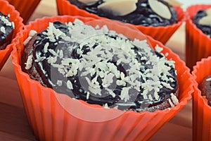 Fresh chocolate muffins with desiccated coconut and dried almonds. Delicious dessert