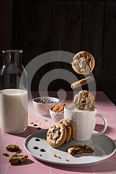 Fresh chocolate ship cookies making splash in a cup of milk