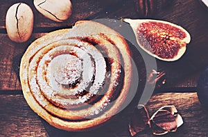 Fresh cinnamon bun with pecan nuts topped with sugar powder