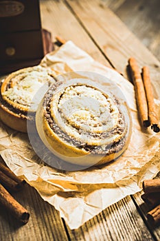 Fresh cinnamon buns on the rustic wooden background