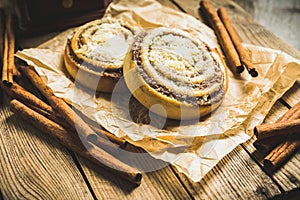 Fresh cinnamon buns on the rustic wooden background