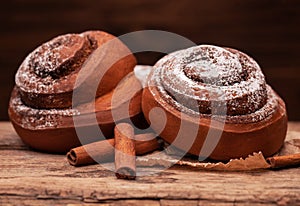 Fresh cinnamon buns on wooden background. Sweet cinnamon rolls.