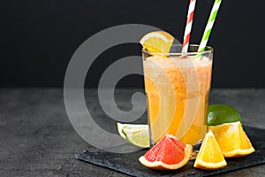 Fresh citrus smoothie juice at dark background.
