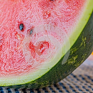 Fresh and clean cut watermelon with blurred background. Concept of freshness and summer time on the beach