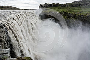 Fresh clean Dettifoss waterfall in Iceland in summer with loads of water flowing and mistg