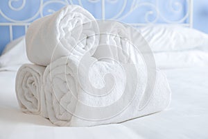 Fresh and clean nicely rolled up towels lie on a bed