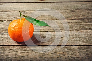 Fresh Clementine or Mandarin orange with leaves on wooden background