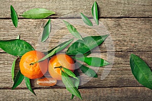 Fresh Clementine or Mandarin orange with leaves on wooden background.