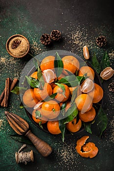 fresh clementines tangerines with spices on dark greeen backgroun