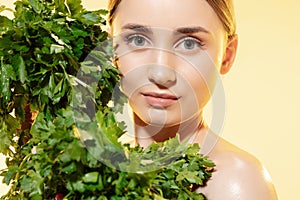 Fresh. Close up of beautiful female face with green leaves over white background. Cosmetics and makeup, natural and eco