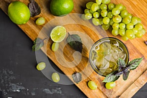 Fresh cocktail with grape, lime and basil leaves