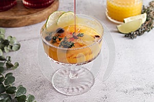 Fresh cocktail with ice, orange juice and grenadine syrup decorated with berries close-up